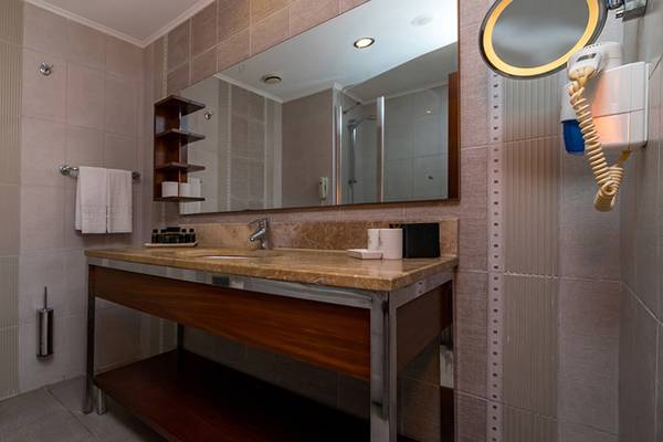 Badezimmer im Kamelya Aishen K Club Hotel mit Waschbecken, Spiegel und Toilette