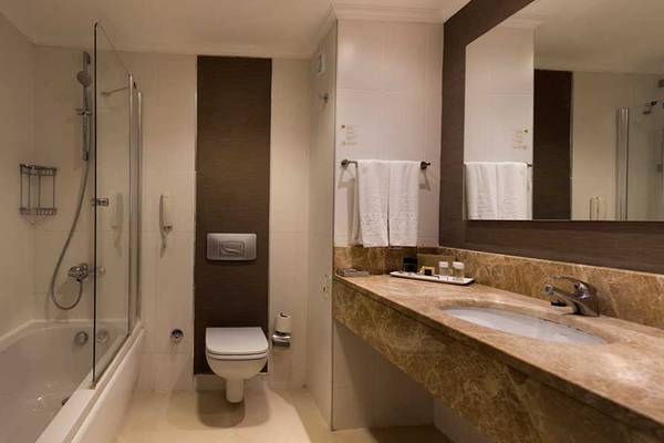 Das Badezimmer des Kamelya Aishen K Club Hotels mit Badewanne, Dusche, Toilette und Waschbecken.