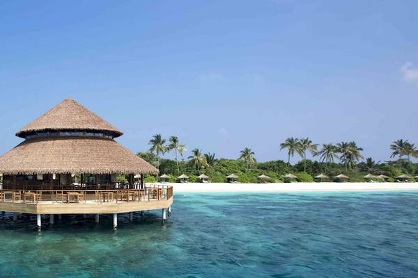 Wasserbungalow im Reethi Faru Resort auf einer Insel mit Palmen und Strand