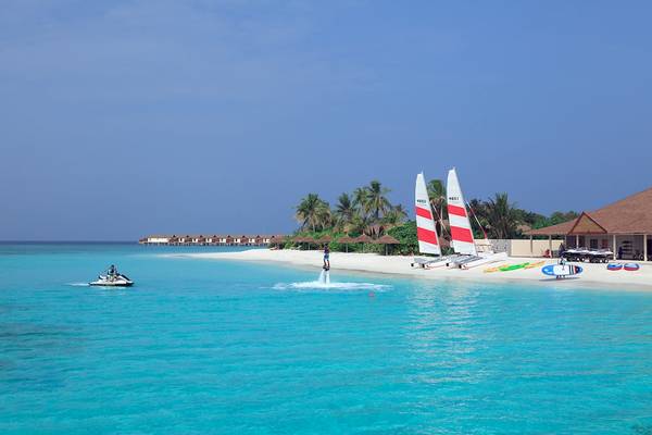 Beeindruckende Strände am Reethi Faru Resort mit Wassersportaktivitäten und bunten Segelbooten.