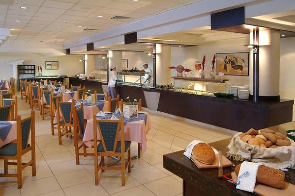 Innenansicht des Restaurants im Nestor Hotel mit besetzten Tischen und serviertem Brot.
