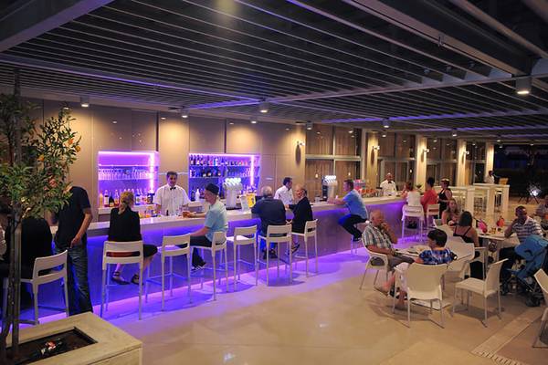 Innenansicht der Bar im Nestor Hotel mit Gästen an der Theke und Tischen