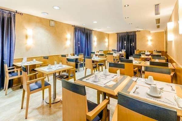 Frühstücksraum im Del Mar - Barcelona Hotel mit gedeckten Tischen und Stühlen