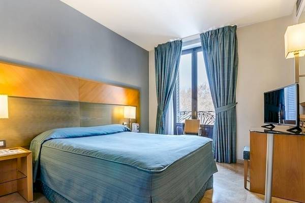 Hotelzimmer im Del Mar Barcelona mit Bett, Fernseher und Fenstern.
