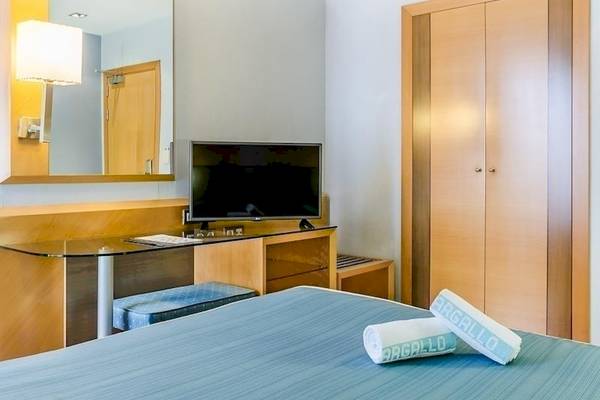 Hotelzimmer im Del Mar Hotel in Barcelona mit Fernseher, Schreibtisch und Schränken