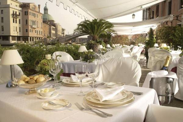 Gartentisch im Principe Hotel Venedig mit Tischdekoration und Blick auf die Stadt.