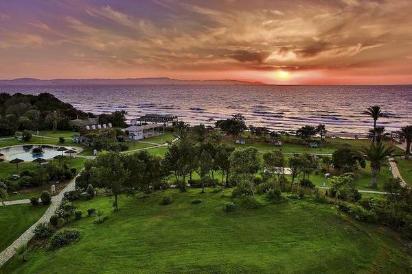 Luftaufnahme des Robinson Kyllini Beach Hotels mit Pool und Meer bei Sonnenuntergang