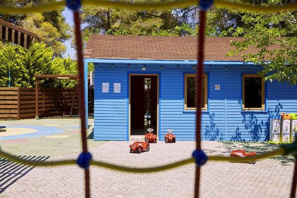 Ein blaues Kinderspielhaus im Freien des Robinson Kyllini Beach Hotels.