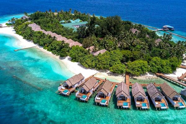 Luftaufnahme des Amaya Kuda Rah Hotels auf einer Insel mit mehreren Wasserbungalows und türkisfarbenem Wasser.