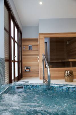 Whirlpool im Zoetry Curacao Resort & Spa mit blauen Fliesen und einer Tür zur Sauna.