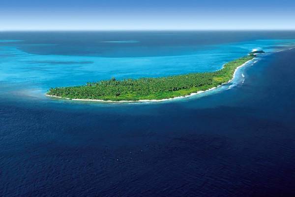 Luftaufnahme der kleinen Insel Atmosphere Kanifushi Maldives, umgeben von blauem Wasser