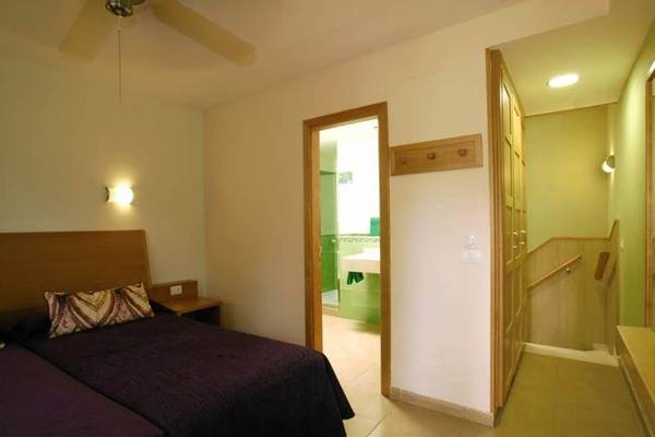 Schlafzimmer im Bungalows Cordial Green Golf Hotel mit zwei Betten und grüner Wand.