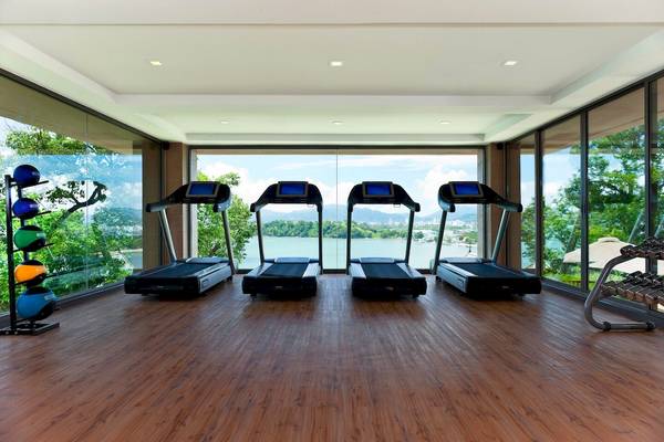 Fitnessstudio im Westin Siray Bay Resort & Spa, Phuket, mit drei Laufbändern und großen Fenstern.