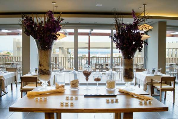 Innenansicht des Restaurants Oasis Salinas Sea mit Tischdekoration und Blick auf das Meer.
