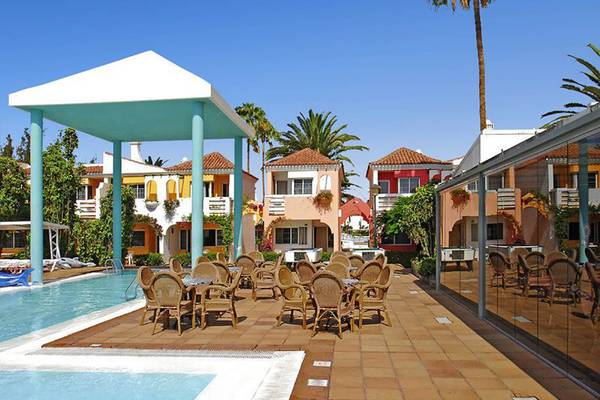 Außenbereich des Bungalows Cordial Green Golf mit Pool und Sonnenliegen.