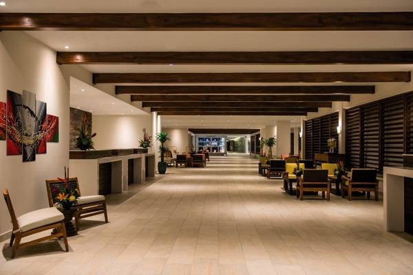 Hotellobby des Holiday Inn Resort Aruba mit langen Fluren und Holzmöbeln.