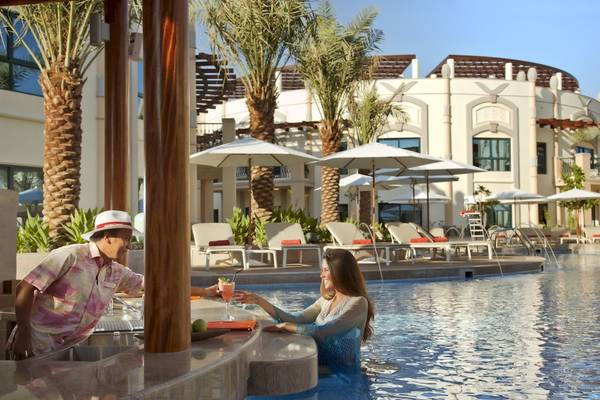 Zwei Personen am Pool des Al Ain Rotana Hotels, mit serviertem Cocktail und entspannter Atmosphäre.