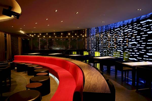 Innenbereich des Al Ain Rotana Hotels mit rotem Sitzbereich und moderner Beleuchtung.