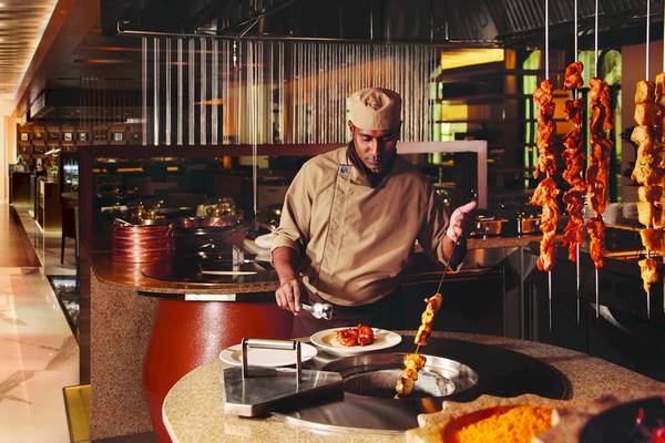 Koch im Al Ain Rotana Hotel, der im Restaurant würzige Fleischspieße grillt.