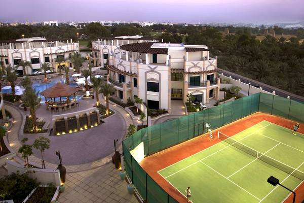 Luftaufnahme des Al Ain Rotana Hotels mit Swimmingpool, Tennisplatz und umliegender Landschaft
