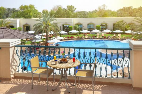 Frühstück auf dem Balkon mit Blick auf den Pool im Al Ain Rotana Hotel.
