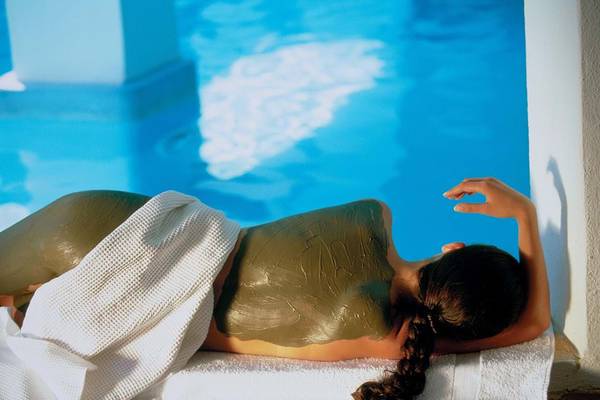 Frau mit Moorpackung am Pool des Elounda Beach Hotel & Villas