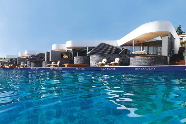 Außenpool des Elounda Beach Hotel mit modernen Gebäuden im Hintergrund.