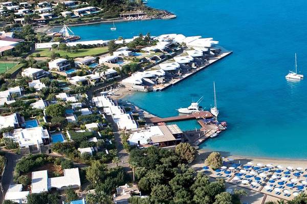 Luftaufnahme des Elounda Beach Hotel & Villas mit Blick auf den Hafen, Boote und die blaue Lagune.