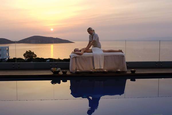 Abendmassage am Pool im Elounda Beach Hotel & Villas mit Blick auf den Sonnenuntergang.
