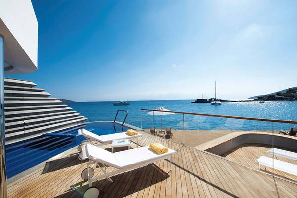 Terrasse des Elounda Beach Hotel mit Blick auf das Meer, Loungestühlen und einem Pool