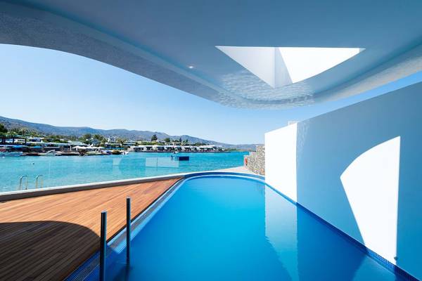 Pool-Aussicht vom Elounda Beach Hotel & Villas mit Blick auf das Meer und die Berge.