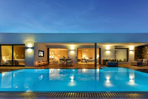 Nachtansicht des Pools des Elounda Beach Hotel & Villas mit beleuchteten Innenräumen