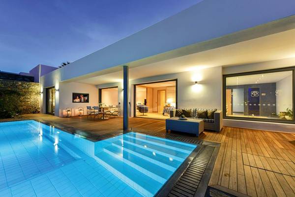 Außenbereich des Elounda Beach Hotel & Villas mit Swimmingpool und Holzterrasse.