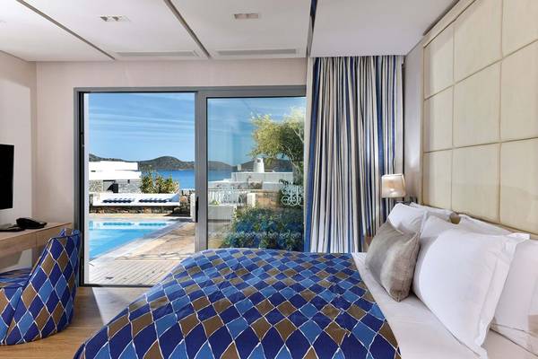 Schlafzimmer im Elounda Beach Hotel & Villas mit Blick auf den Pool und das Meer