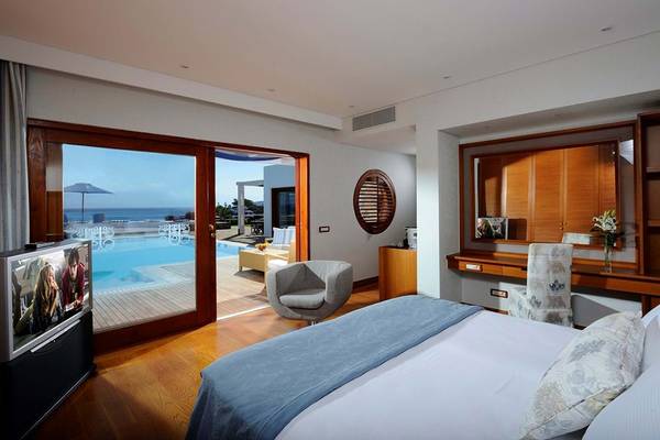 Innenansicht eines Zimmers im Elounda Beach Hotel & Villas mit Blick auf einen Pool.