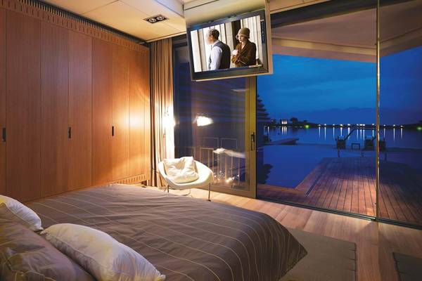 Schlafzimmer im Elounda Beach Hotel mit Aussicht auf den See und eine Terrasse.