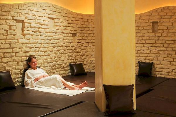 Eine Frau liegt in einem weißen Handtuch auf einer Liege in einem Spa-Bereich des Djerba Resorts.