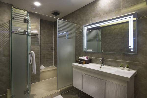 Badezimmer des Pickalbatros Aqua Blu Resort - Sharm mit Duschkabine, Spiegel und Waschbecken.