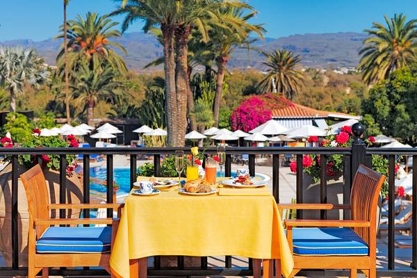 Frühstückstisch auf der Terrasse des Seaside Grand Hotel Residencia mit Blick auf den Pool