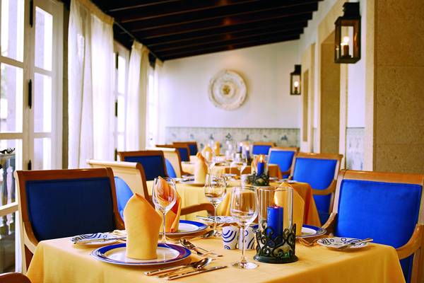 Restauranttisch im Seaside Grand Hotel Residencia mit blauen Stühlen und gelben Tischdecken.