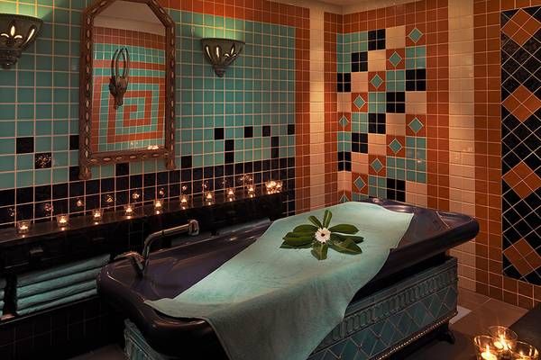 Badezimmer im Seaside Grand Hotel Residencia mit blauen und schwarzen Fliesen und einem Badewanne.