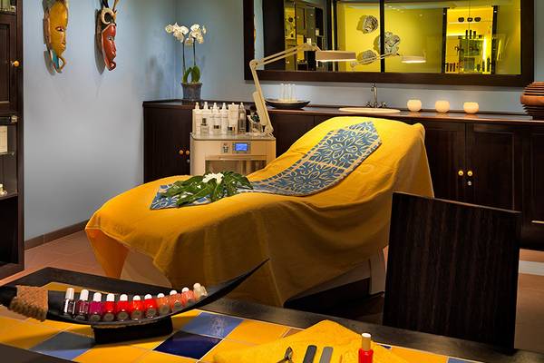 Wellnessbereich im Seaside Grand Hotel Residencia mit gelbem Liegestuhl und Kosmetikprodukten.