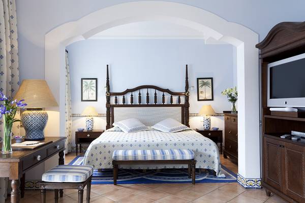 Schlafzimmer im Seaside Grand Hotel Residencia mit Doppelbett, Nachttischen, Lampen und Fernseher.