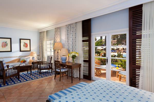 Suite-Innenansicht im Seaside Grand Hotel Residencia mit Blick auf den Pool.