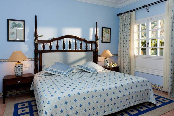 Schlafzimmer im Seaside Grand Hotel Residencia mit blauer Bettwäsche und blauen Kissen.