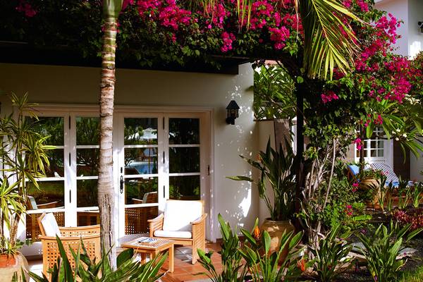 Garten Sitzbereich des Seaside Grand Hotel Residencia mit blumengeschmücktem Eingang.