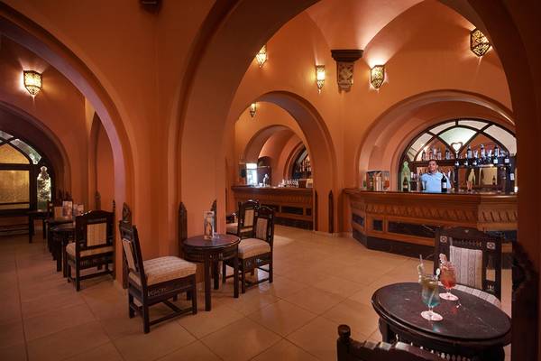Innenansicht der Bar im Arabella Azur Beach Resort mit Barkeeper und Sitzbereichen.