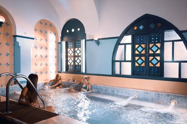 Drei Frauen entspannen in einem Innenpool des Arabella Azur Beach Resorts.