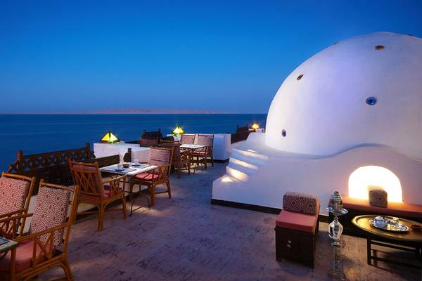Außenbereich des Arabella Azur Beach Resorts mit Blick auf das Meer und runden Tischen.
