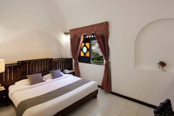Ein elegantes Hotelzimmer mit einem Bett, Tisch und Fernseher im Arabella Azur Beach Resort.
